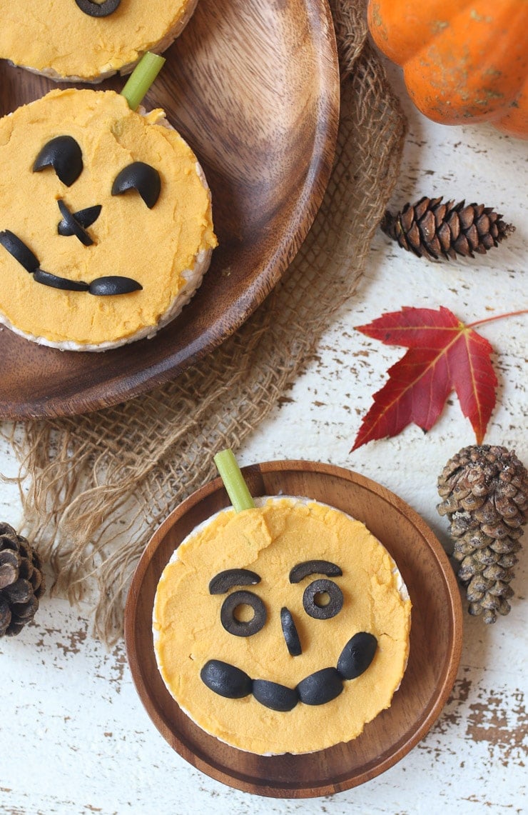 Pumpkin hummus recipe added to rice cakes to make jack-o-lantern face.