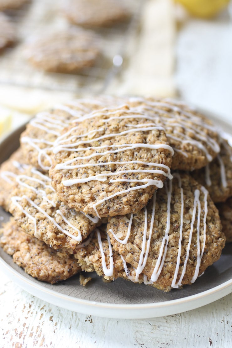 Pile of lemon poppyseed cookies garnished with a glaze on a plate.