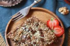 Square of zucchini baked oatmeal on a wooden plate.