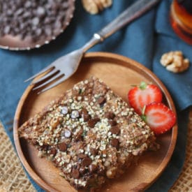 Square of zucchini baked oatmeal on a wooden plate.