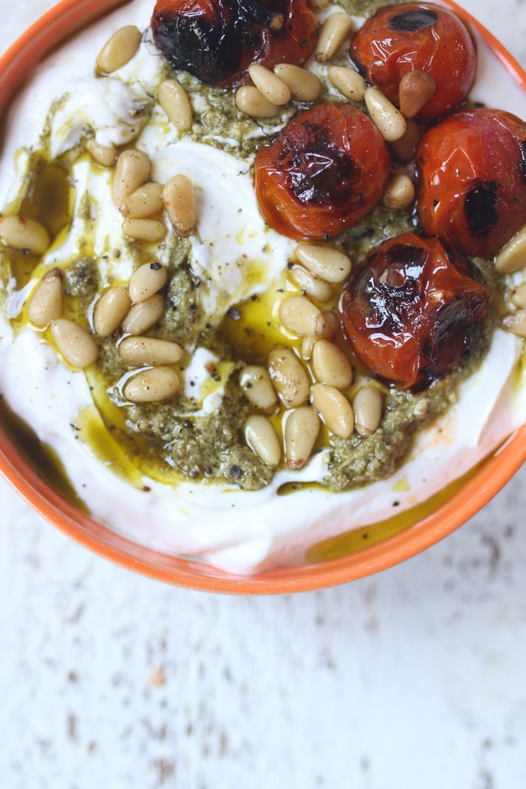greek Yogurt bowl topped with pesto and tomatoes. 