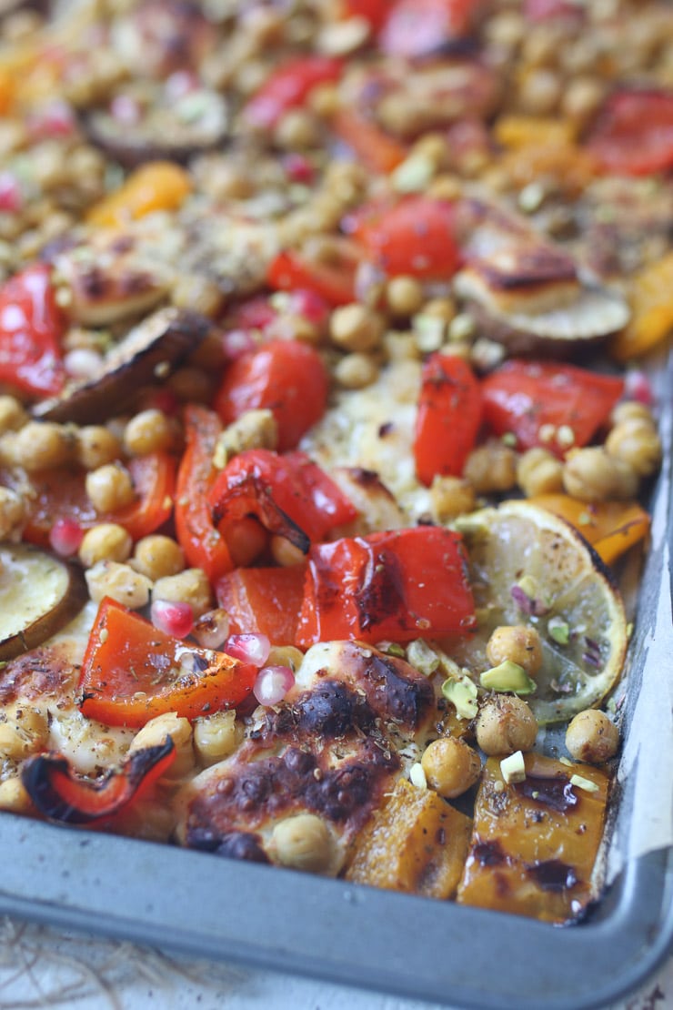 Close up of chickpeas and a variety of vegetables on a sheet pan. 