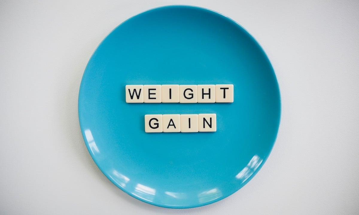 Plate with tiles that spell the word the word: weight gain. 