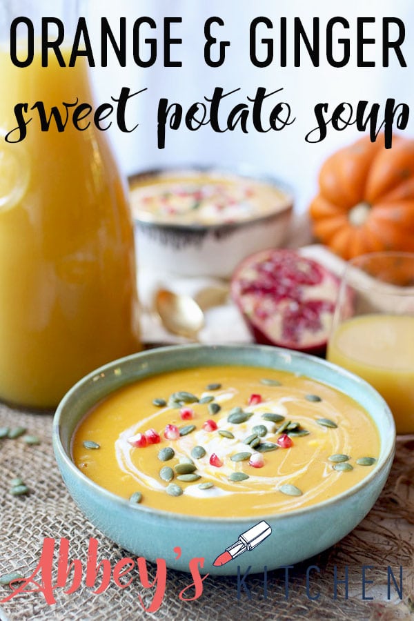 pinterest image of sweet potato and ginger soup soup served in a bowl garnished with pumpkin seeds and pomegranate seeds with text overlay.