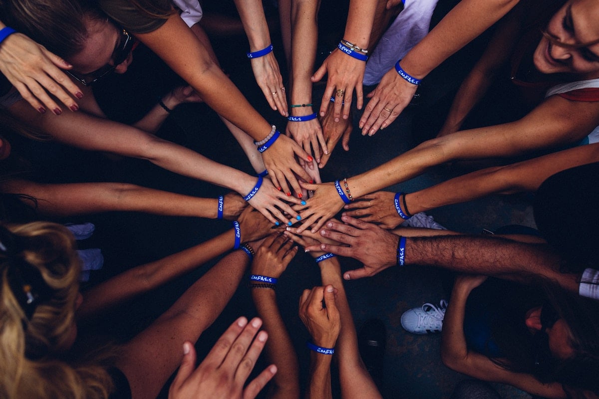 A bunch of people's hands meeting in a circle.
