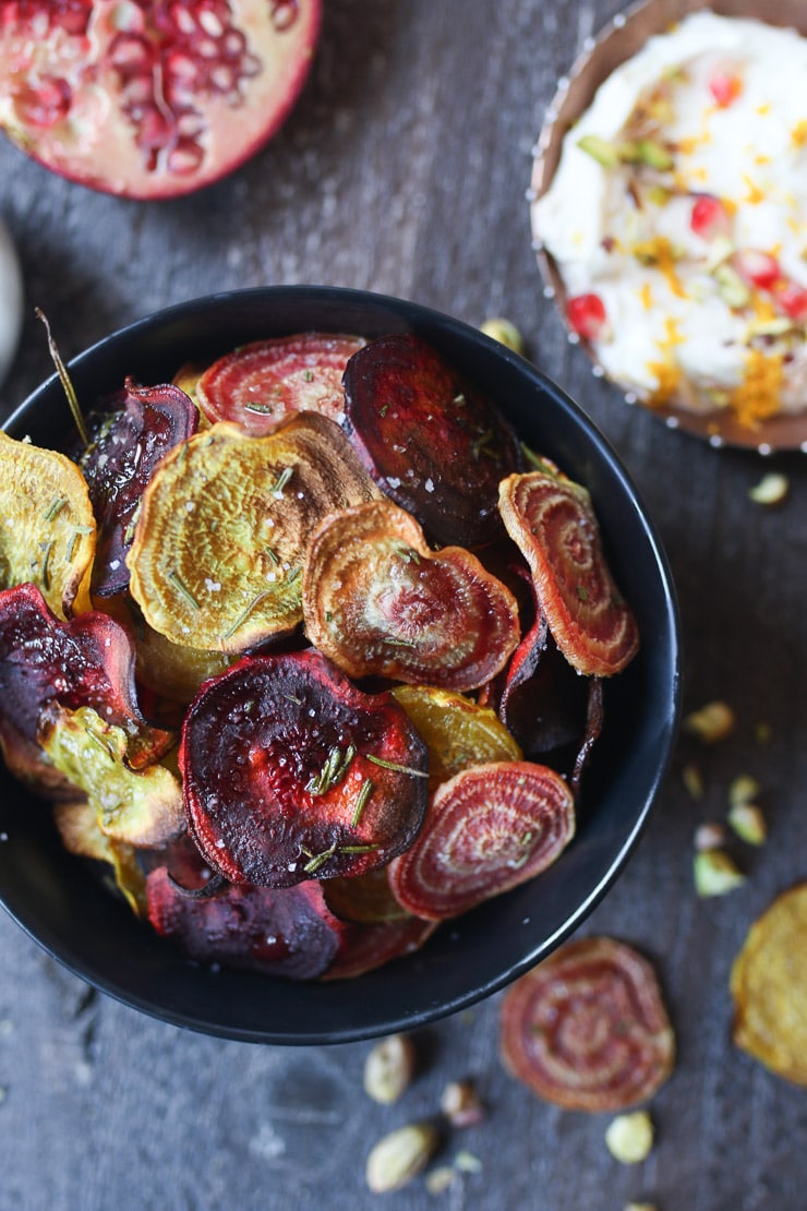 Baked beet chips in a black bowl.