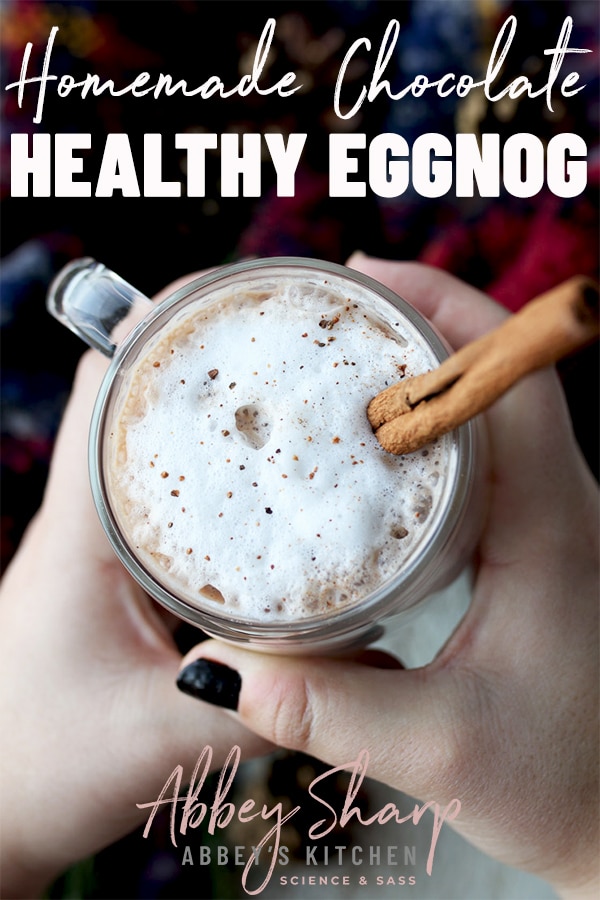 pinterest image of Hands holding homemade eggnog in a glass mug with text overlay