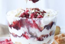 Hand scooping out serving of trifle.