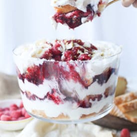 Hand scooping out serving of trifle.
