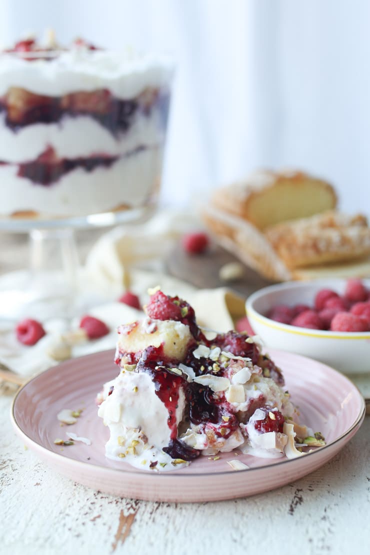 Serving of lemon raspberry trifle on a pink plate.