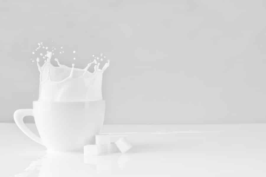 Milk spilling in a white mug.