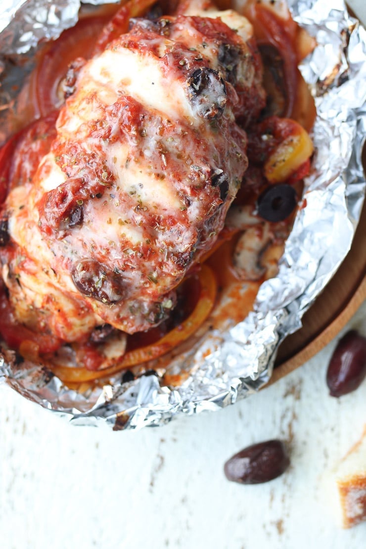 Birds eye view of pizza chicken bake in a foil pack topped with sauce and cheese. 
