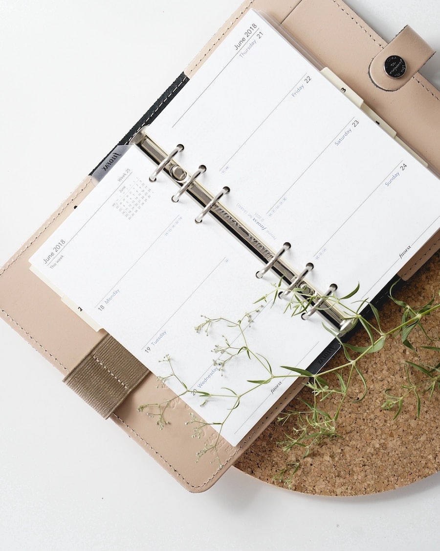 Overhead image of an opened beige and brown filofax planner.