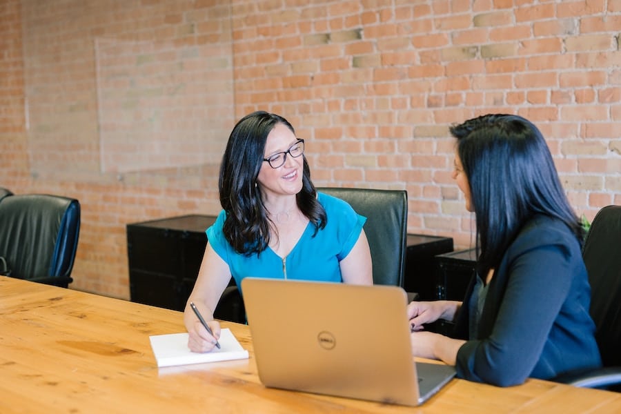 Two women sitting at a table discussing intuitive eating. 