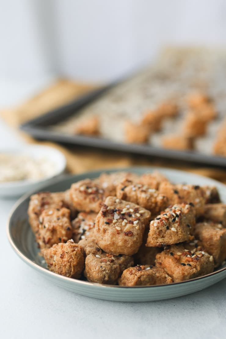 Nuggets topped with seasoning on a teal plate.