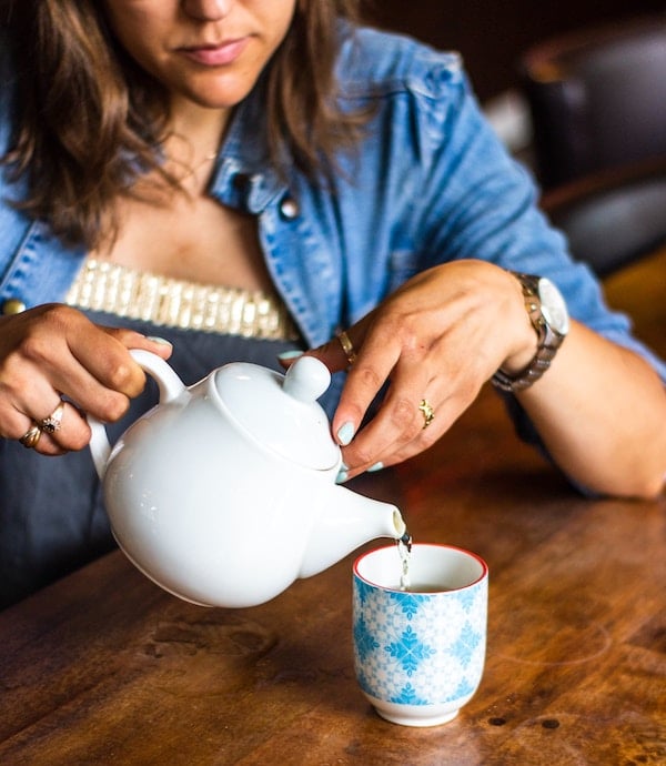 Person pouring tea into a mug. 