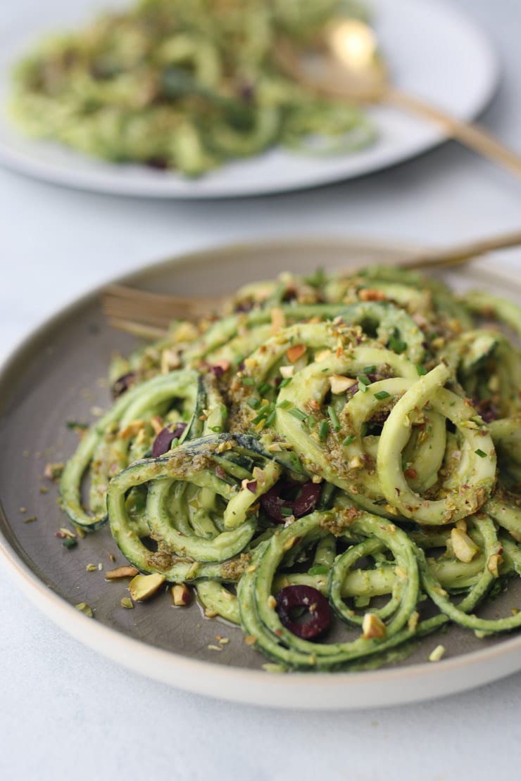 Avocado zucchini zoodles on a grey plate. 