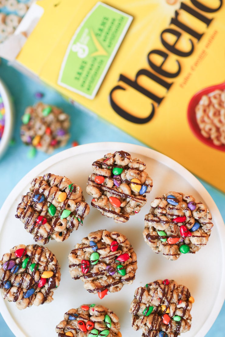 No bake cheerios bars on white plate with cheerios box in background.