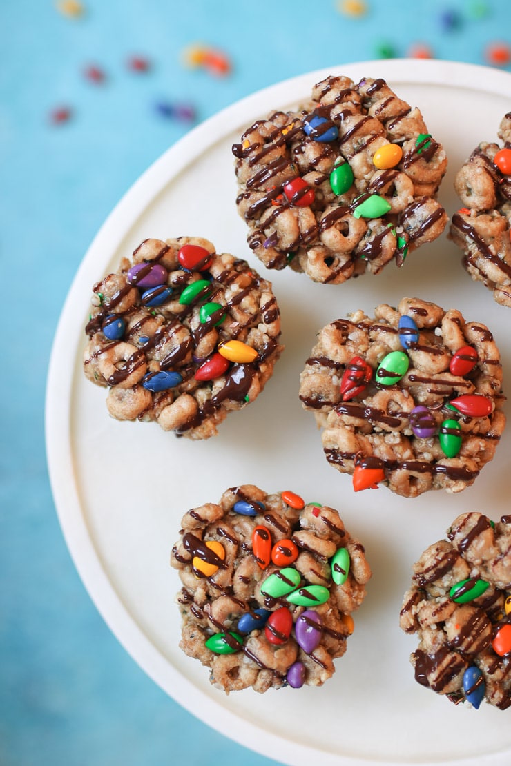 No bake cheerios bars on a white plate drizzled with chocolate.