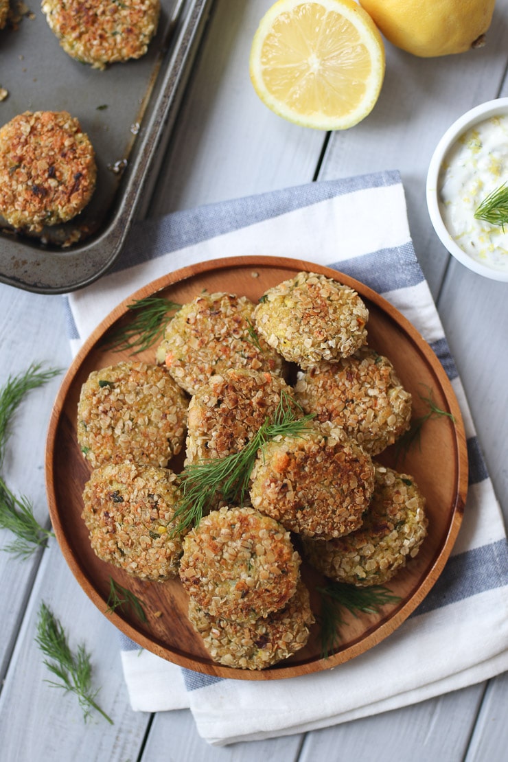 Fish cakes served on a wooden plate garnished with dill.