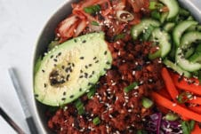 Big bowl containing avocado, veggies and vegan meat.