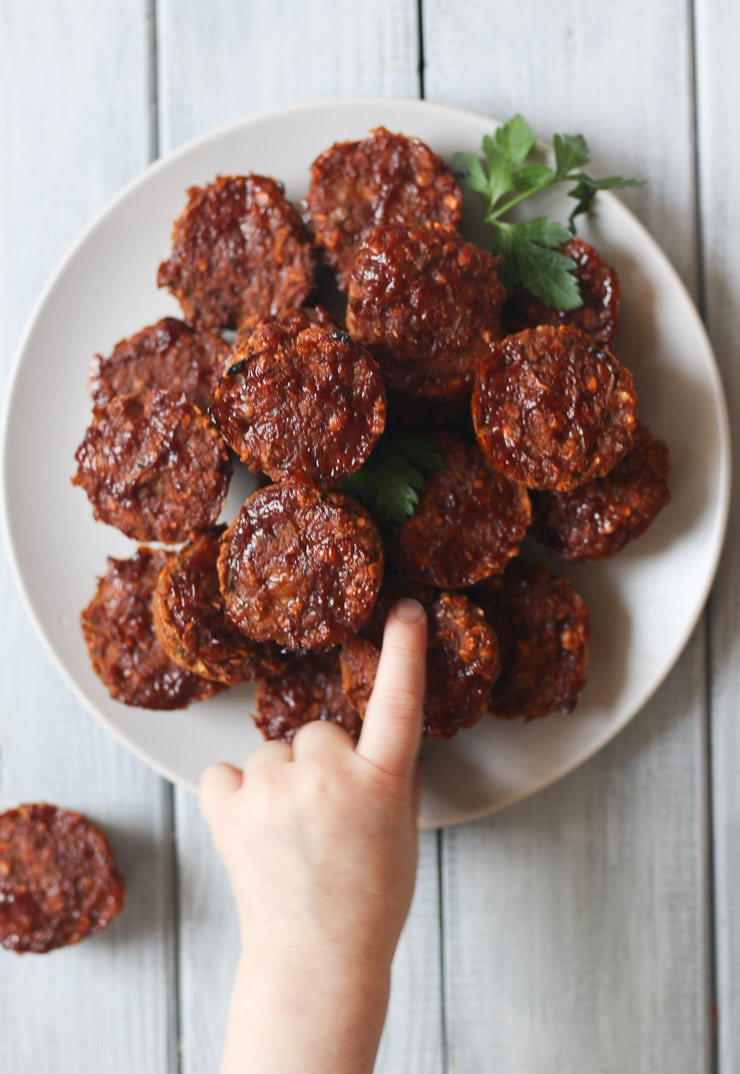 Toddler's hand reaching for mini vegan lentil meatloaf. 