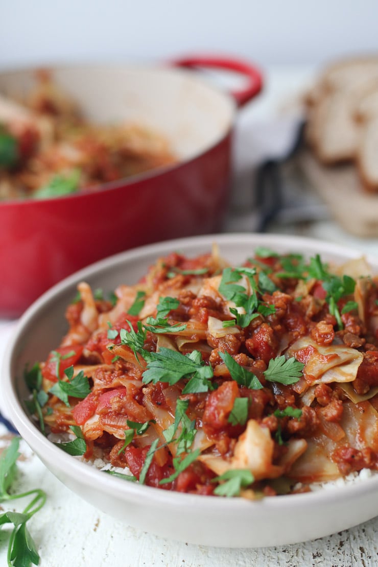 Unstuffed cabbage rolls served in a bowl topped with parsley.