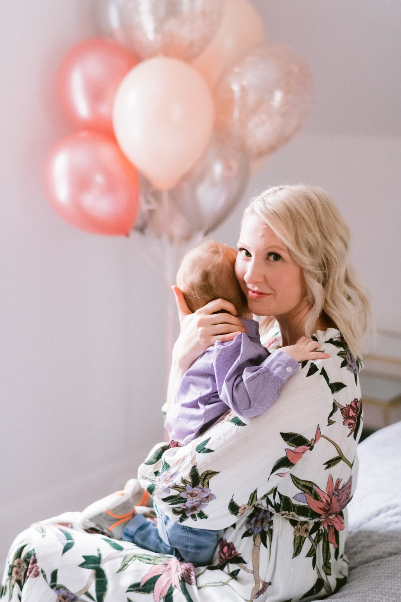 Abbey holding baby E with balloons in the background 