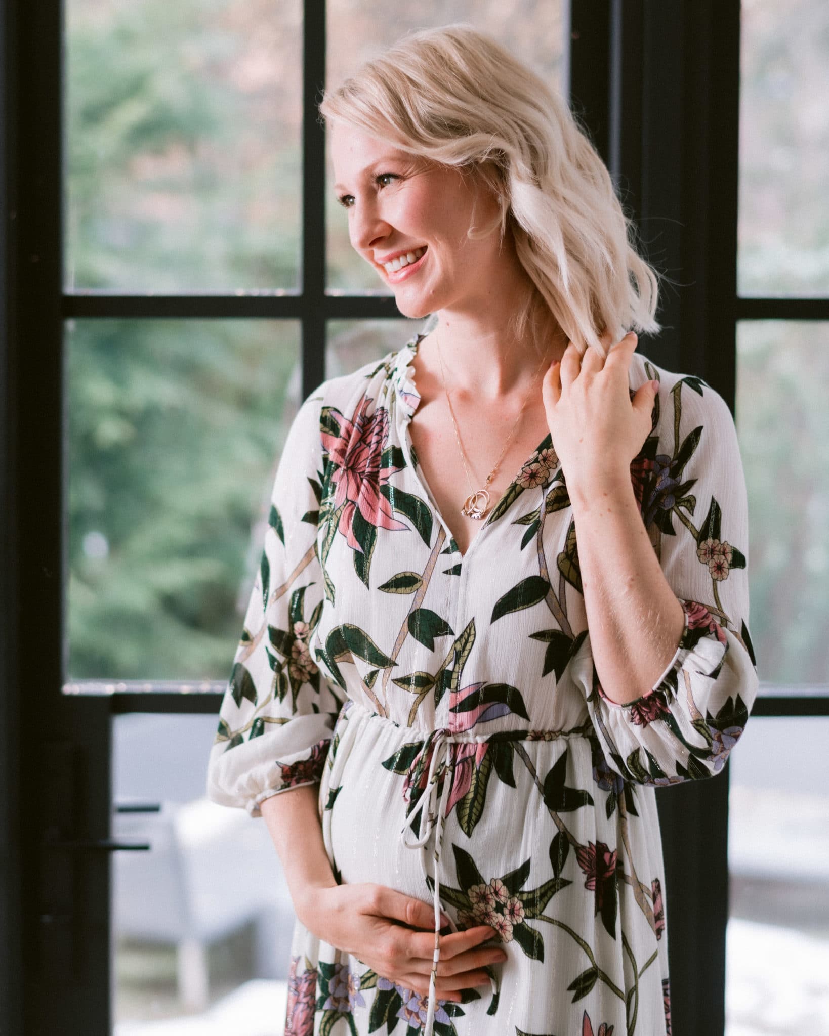 pregnant abbey in floral dress cradling baby bump conceived with thin uterine lining