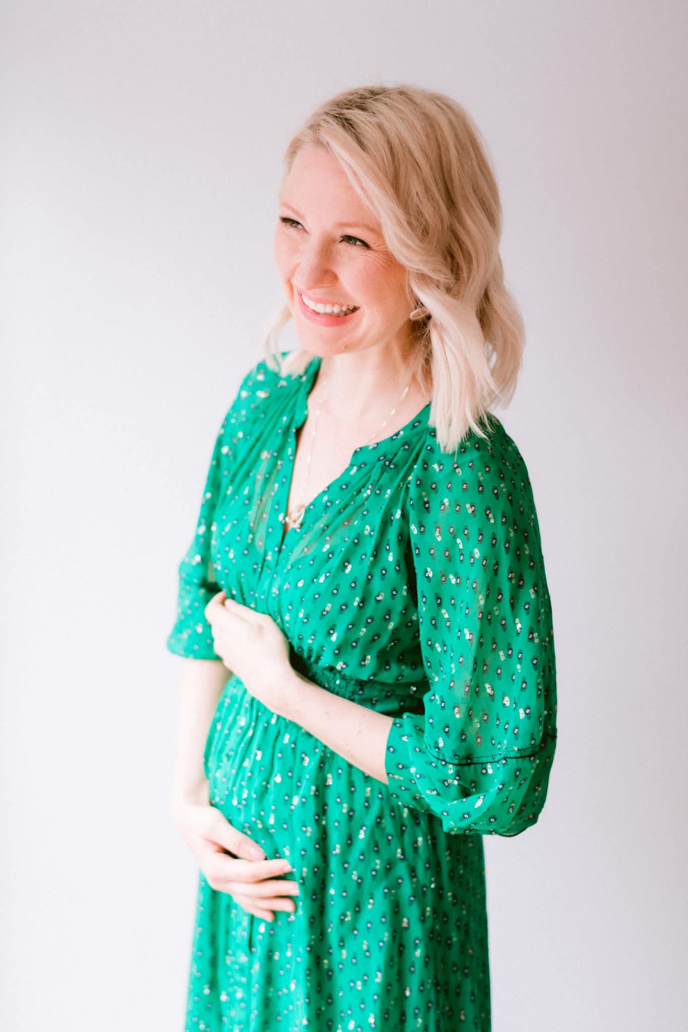 abbey wearing a green dress and showing her baby bump