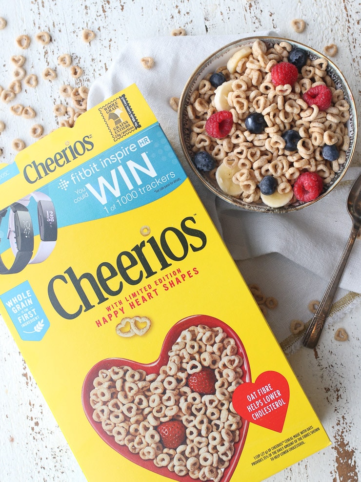 Birds eye view of cheerios box and bowl of cheerios with berries for a heart healthy diet.