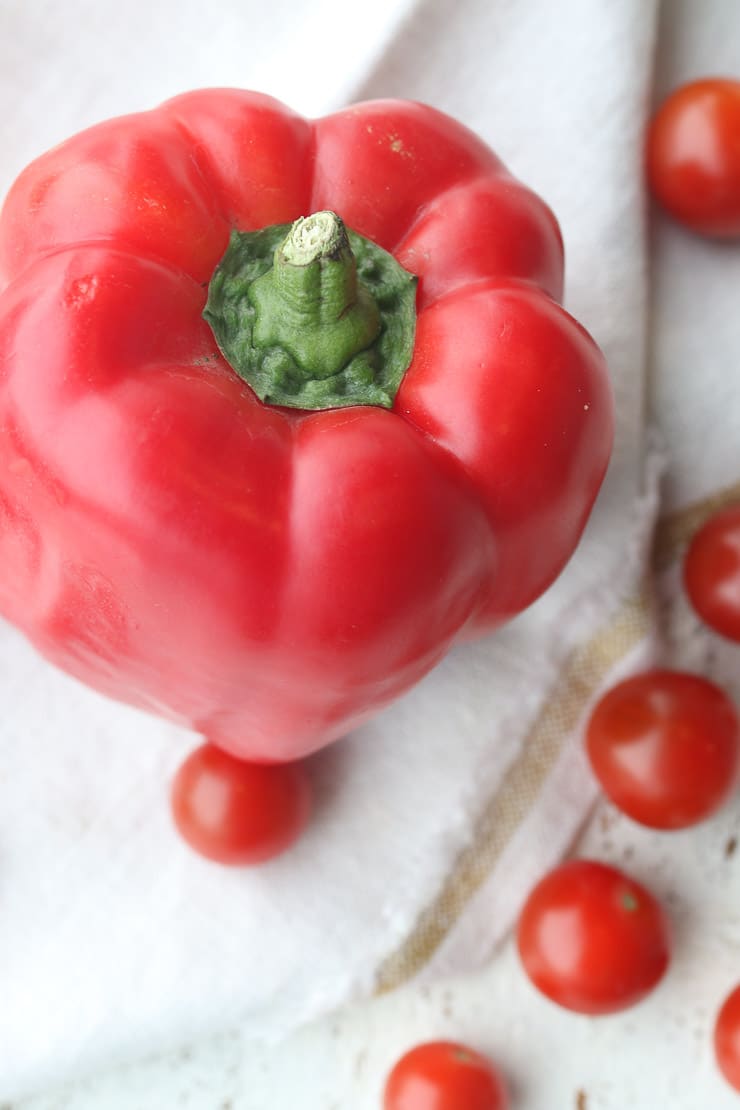 red bell pepper surrounded by grape tomatoes as part of a heart healthy diet