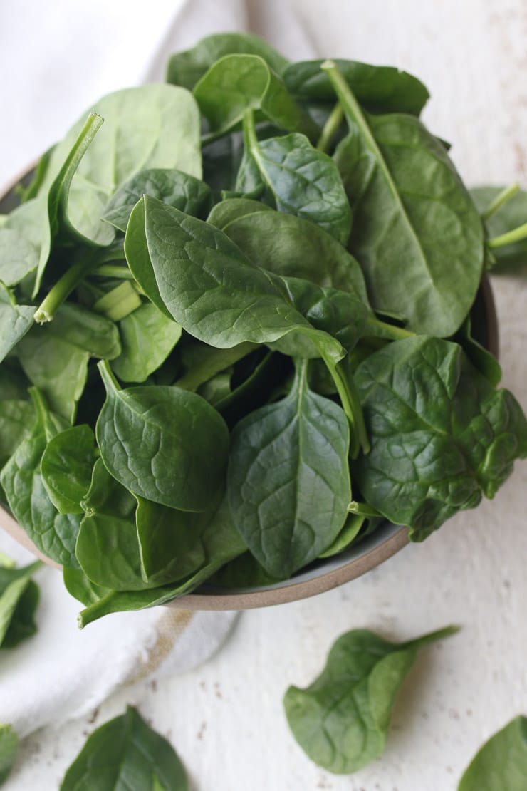 Birds eye view of leafy greens in a white bowl.