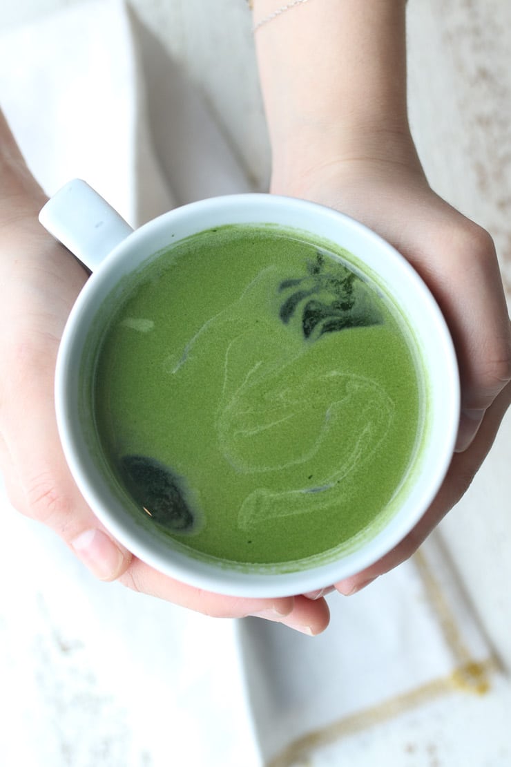 Birds eye view of a white mug containing green tea as one of the best foods for heart health.