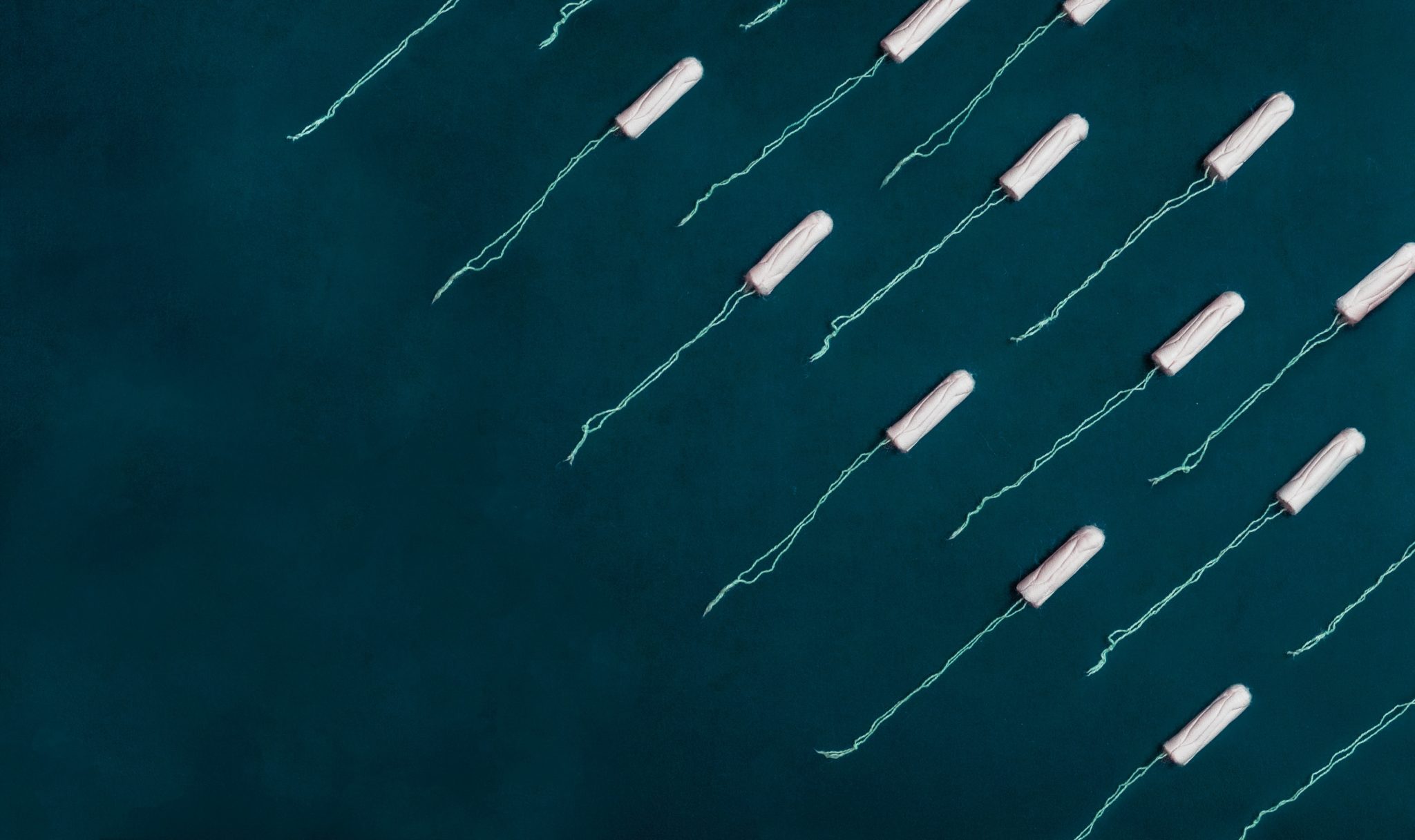 birds eye view of multiple tampons laid out on a dark background