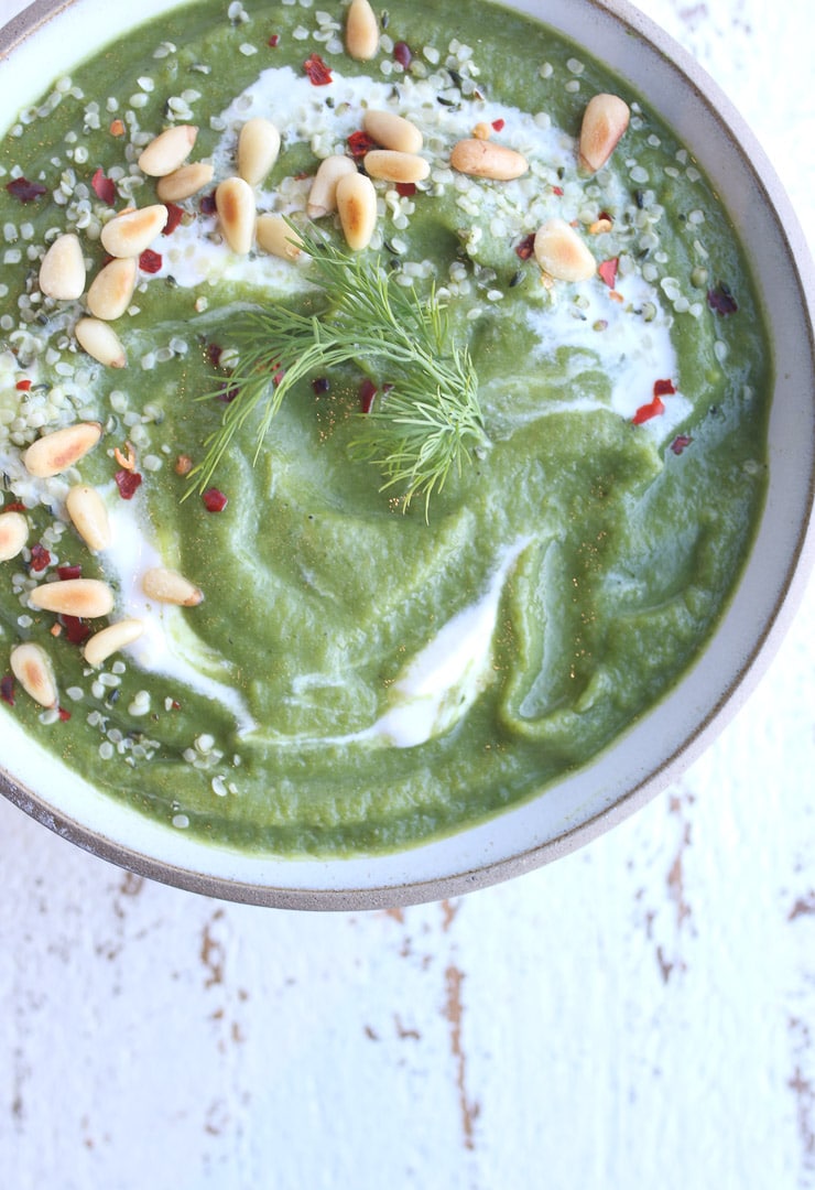 Birds eye view of broccoli white bean soup garnished with dill and pine nuts.