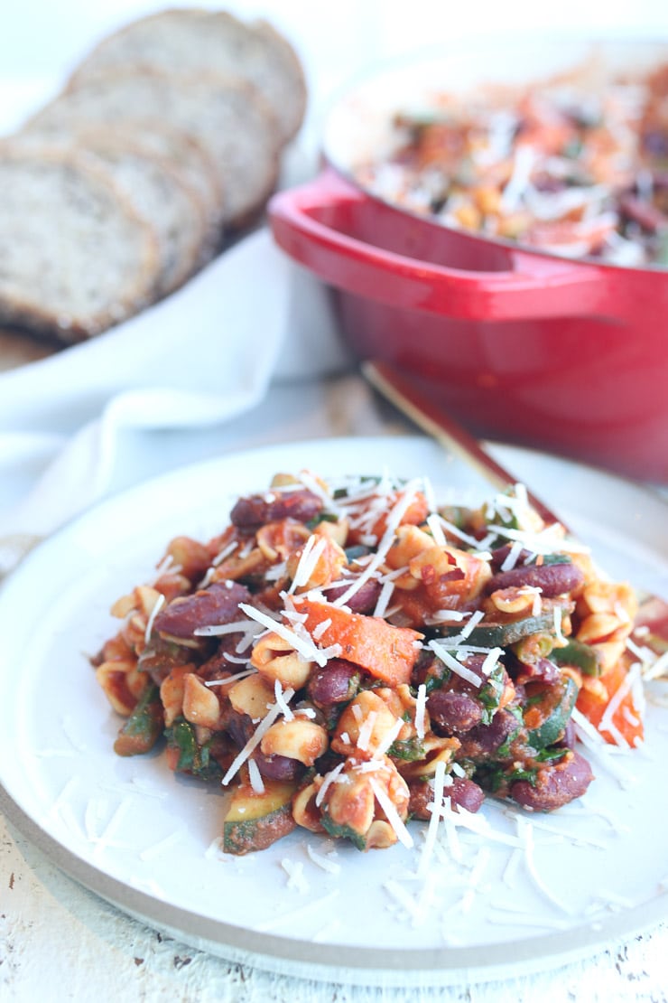 close up of easy vegan gluten free minestrone skillet pasta on a white plate garnished with vegan cheese