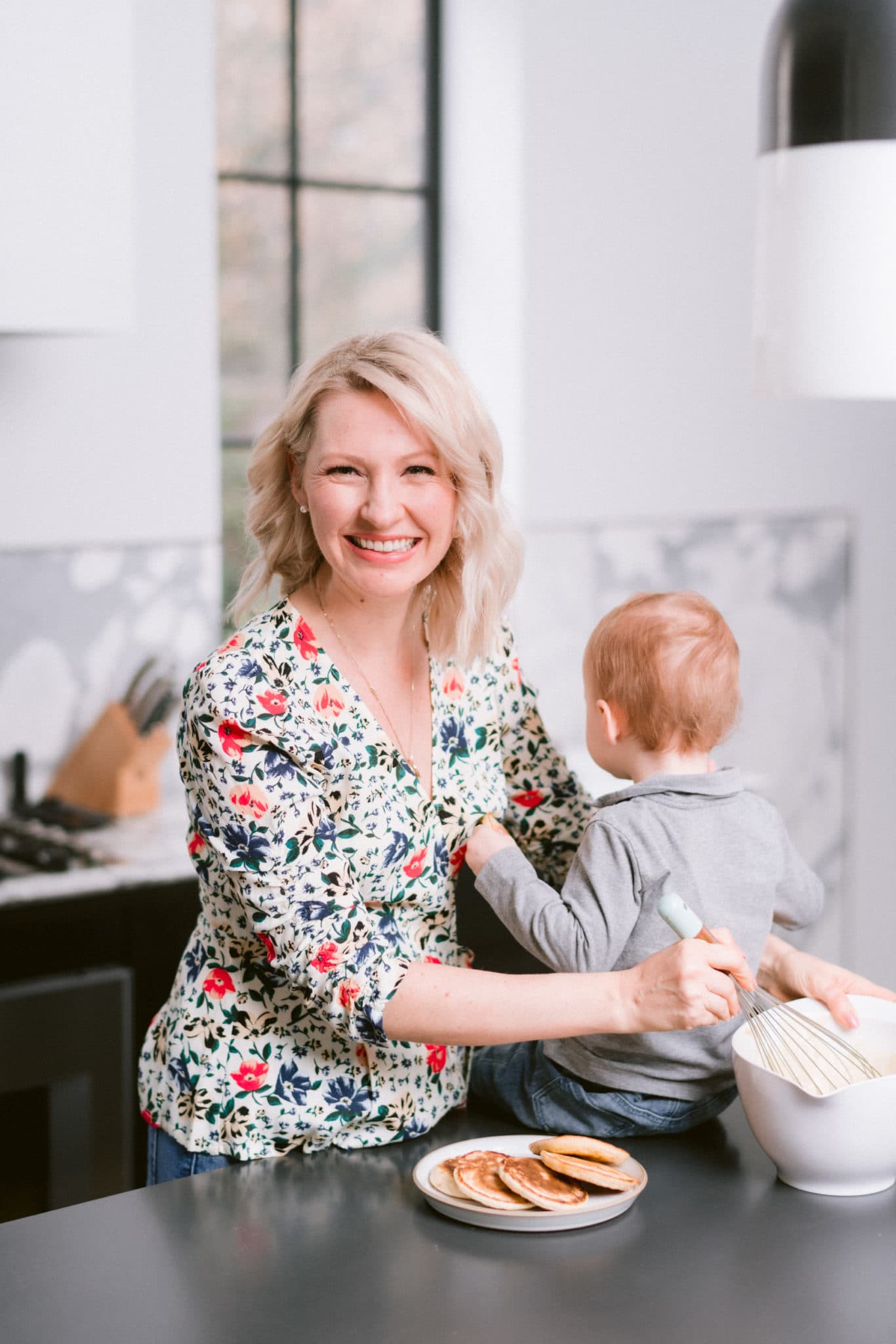 Abbey and her son cooking pancakes together as a fun toddler summer activity.