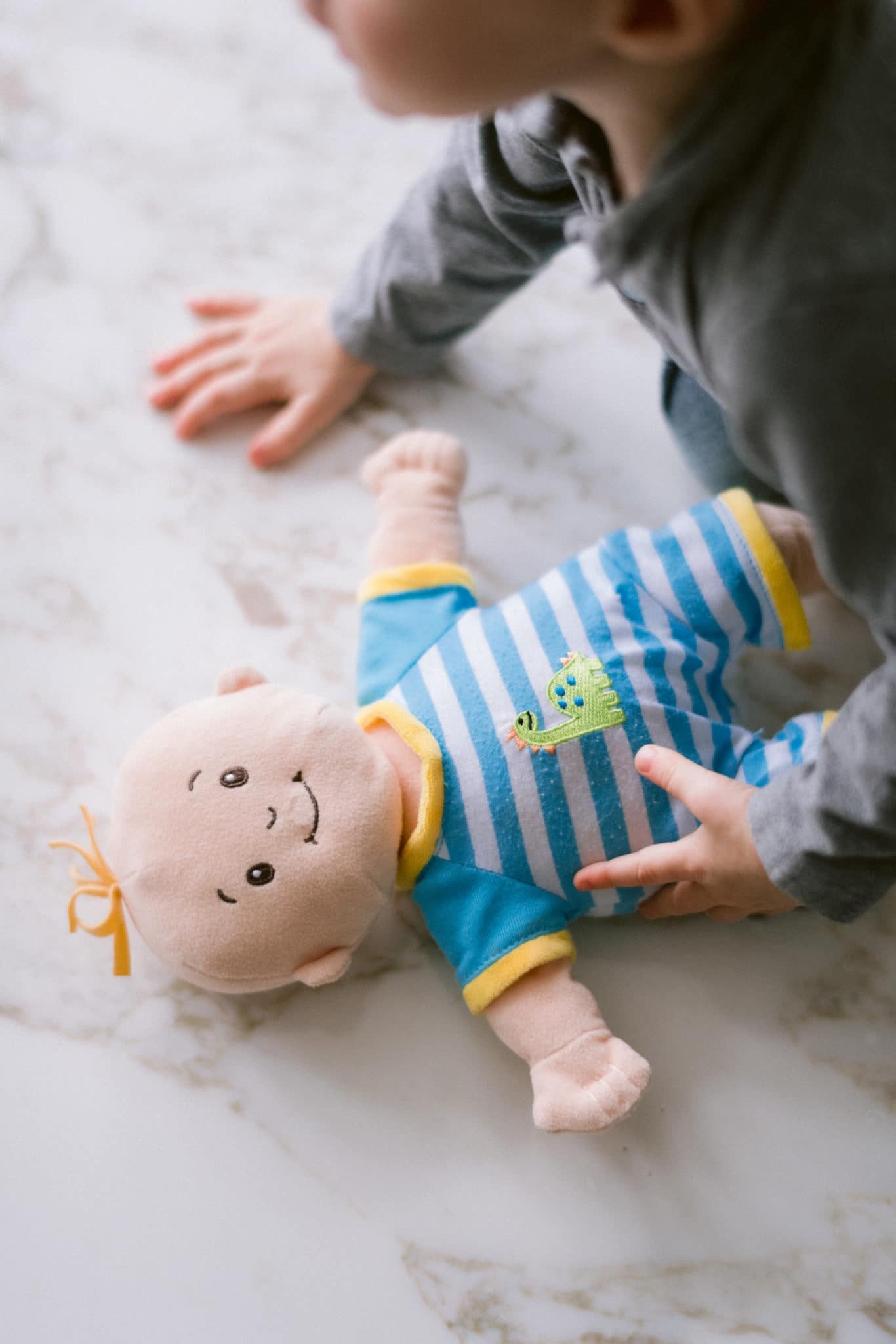Toddler playing with doll.