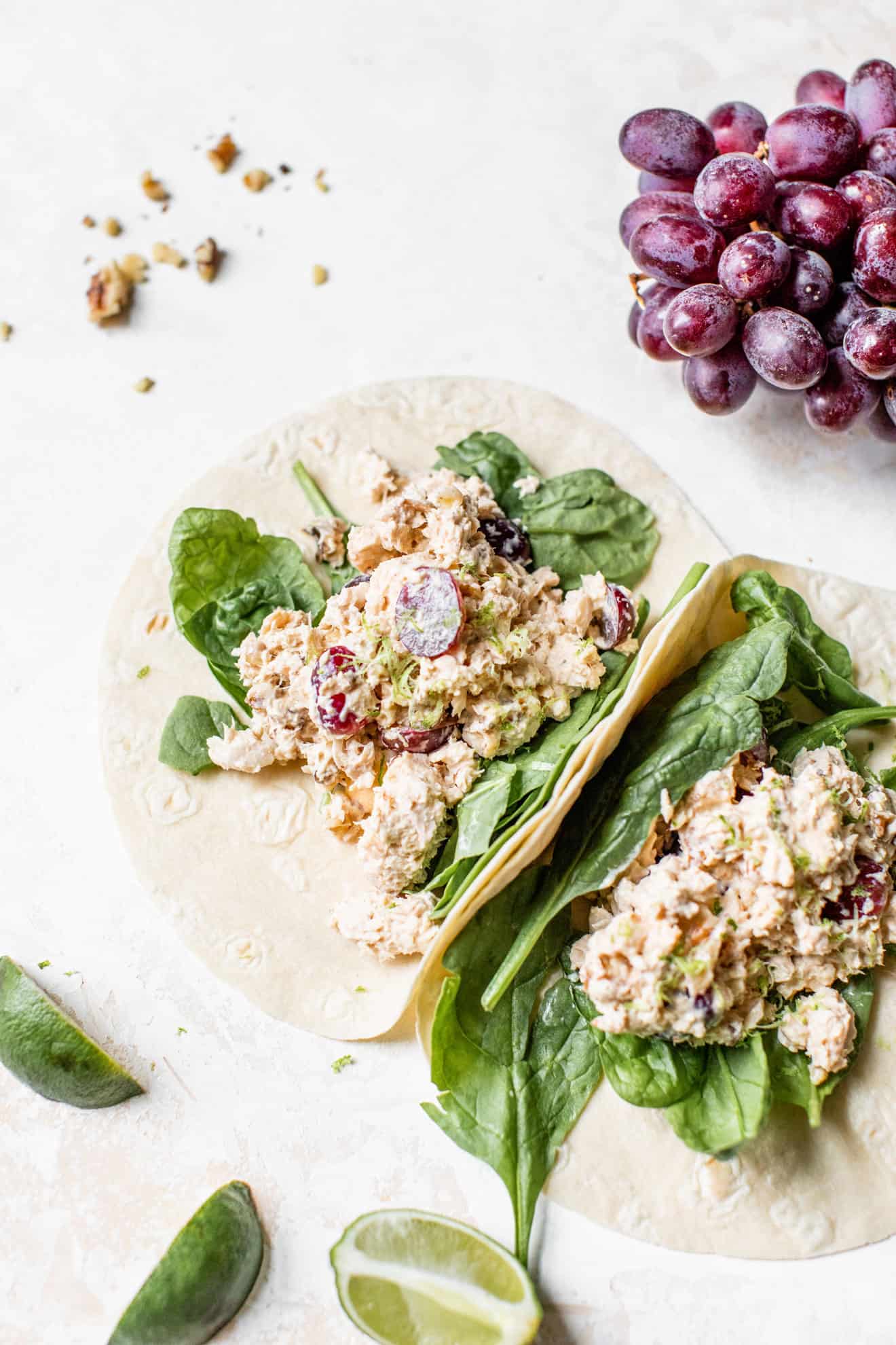 birds eye view of two chipotle lime salmon salad wraps served with fresh greens and a side of red grapes