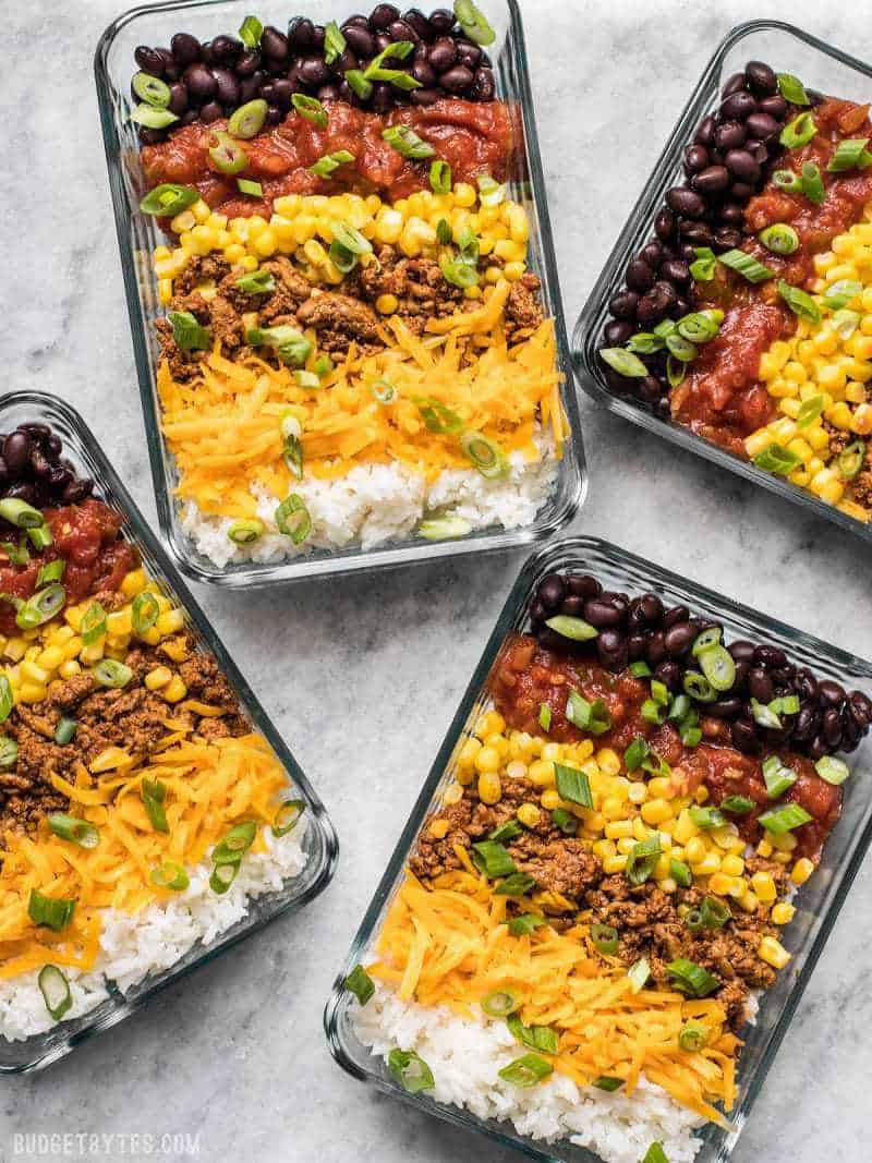 birds eye view of four pantry staple burrito bowls garnished with green onions