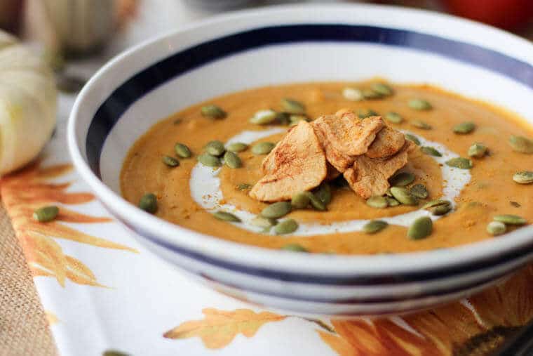 vegan soup recipe in striped bowl topped with seeds 