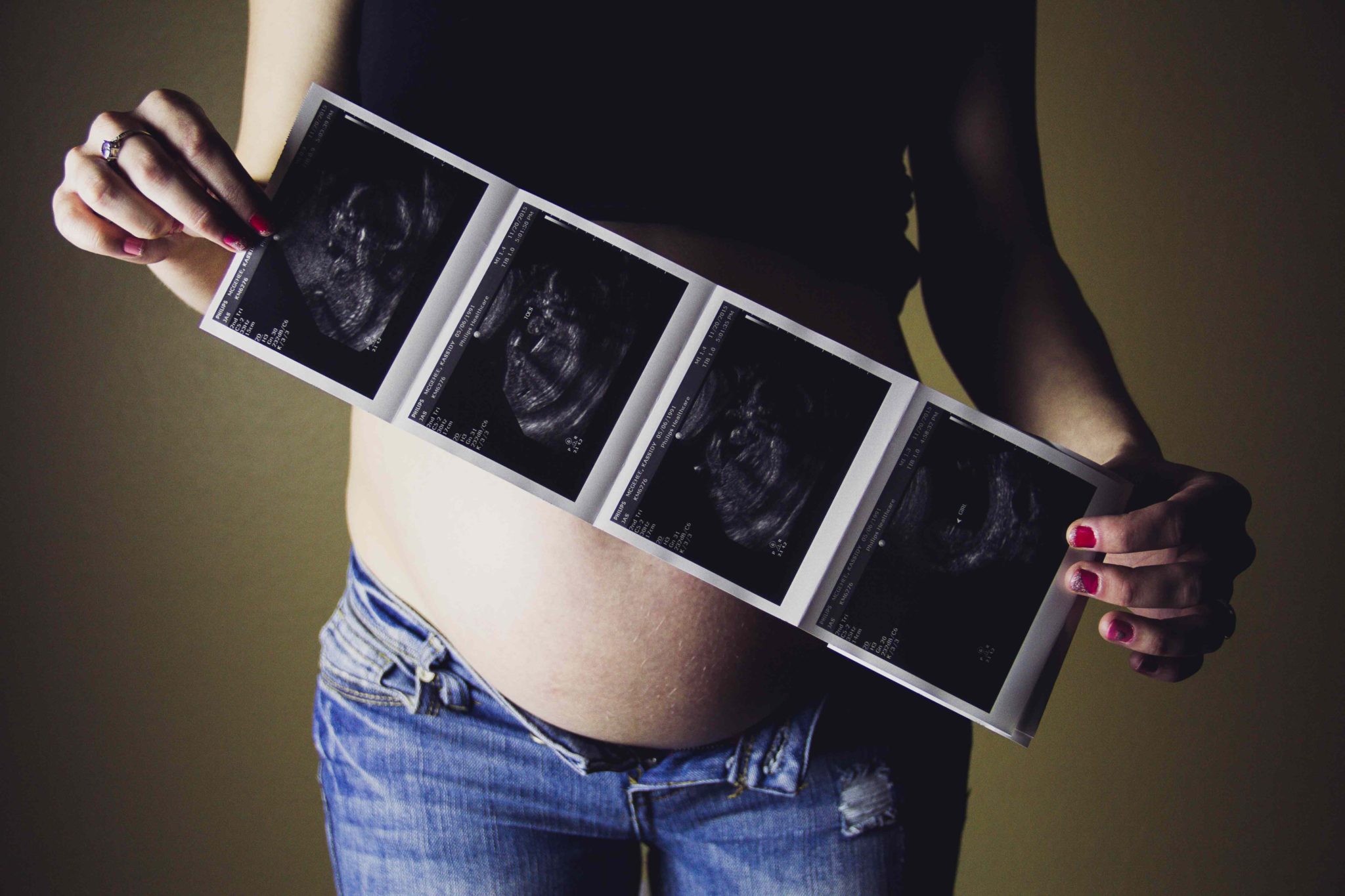 pregnant woman holding ultrasound photo