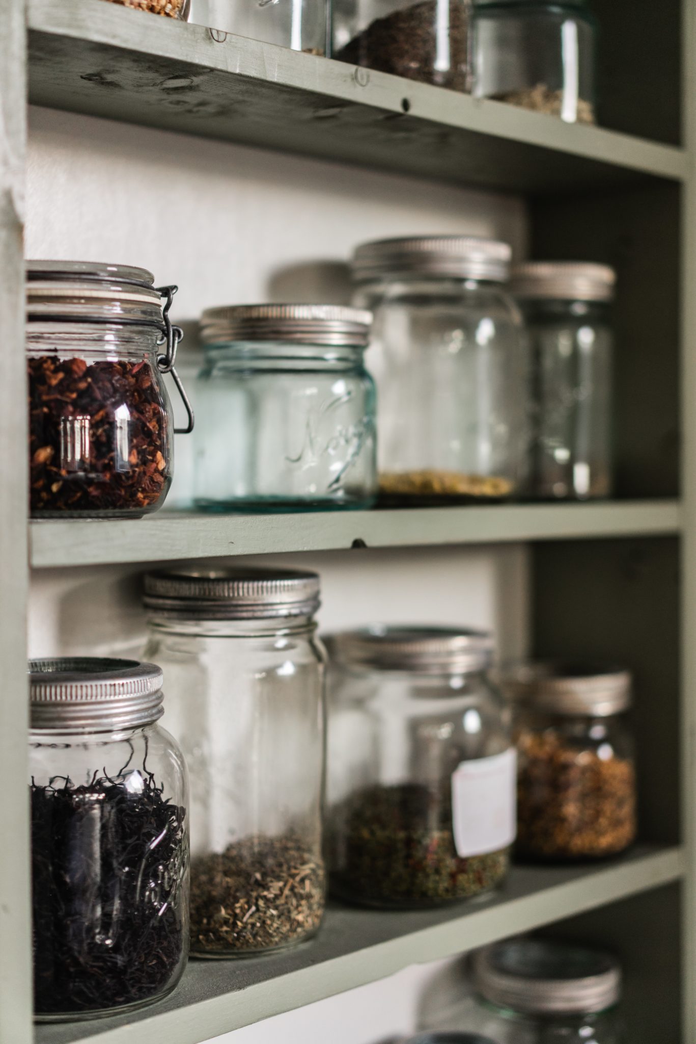 several jars in a pantry shelf representing pantry items to collect for covid-19 isolation 