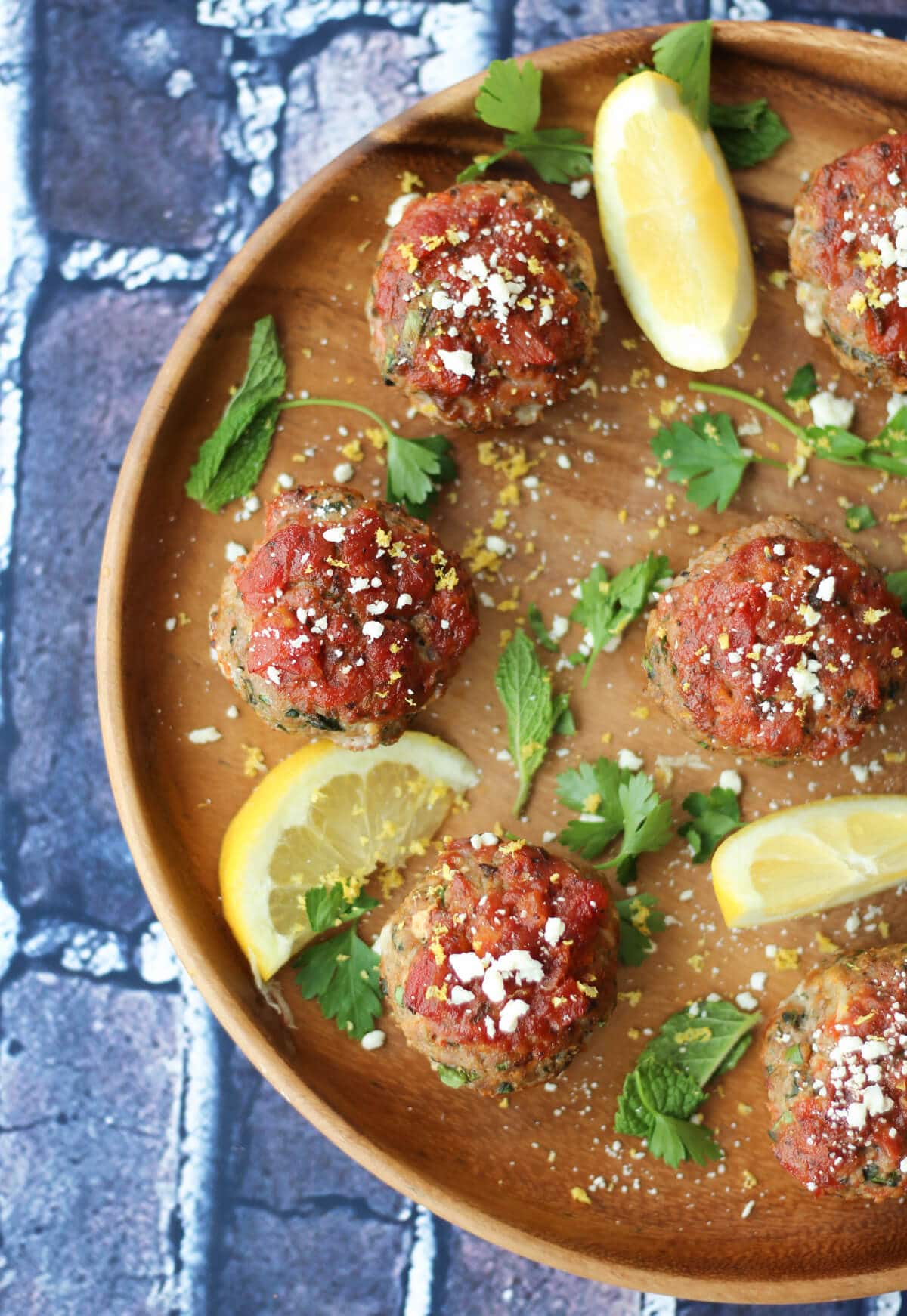 mini meatloaf muffins on a wooden plate garnished with lemon and parsley 