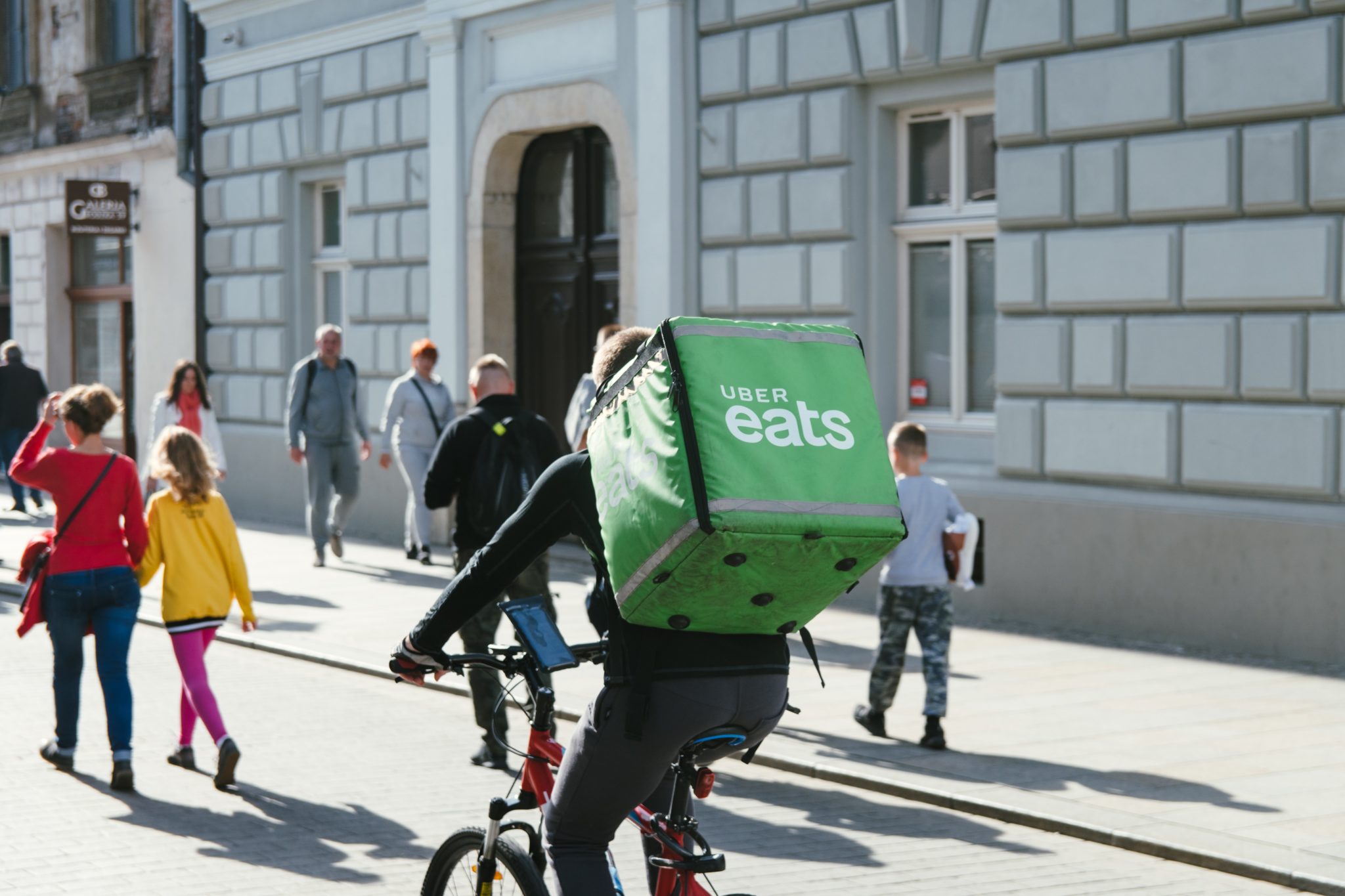 an uber eats delivery person delivering take out food during covid-19 pandemic 