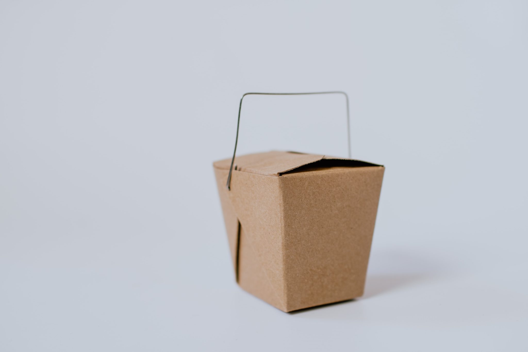 image of a brown take out box against a light grey background