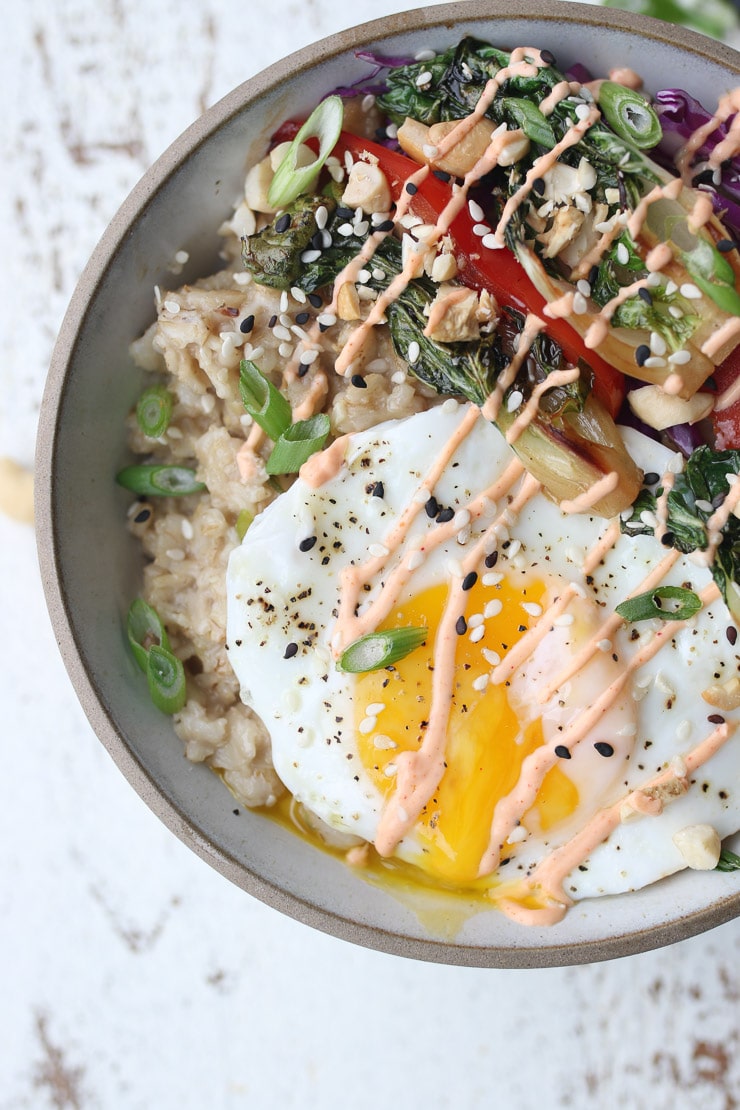 birds eye view of savoury oatmeal bowl with runny egg ontop and a spicy drizzle 