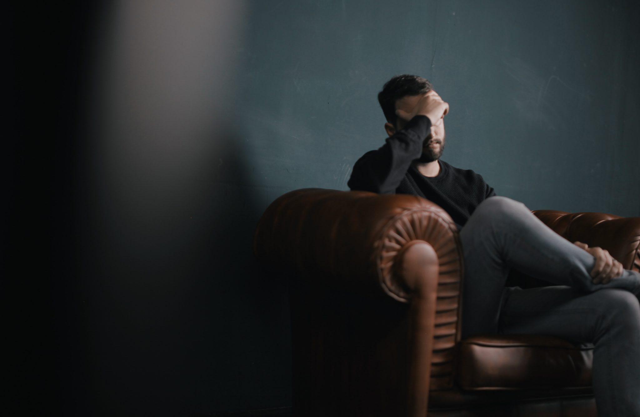 an emotional man sitting on a couch during a therapy session