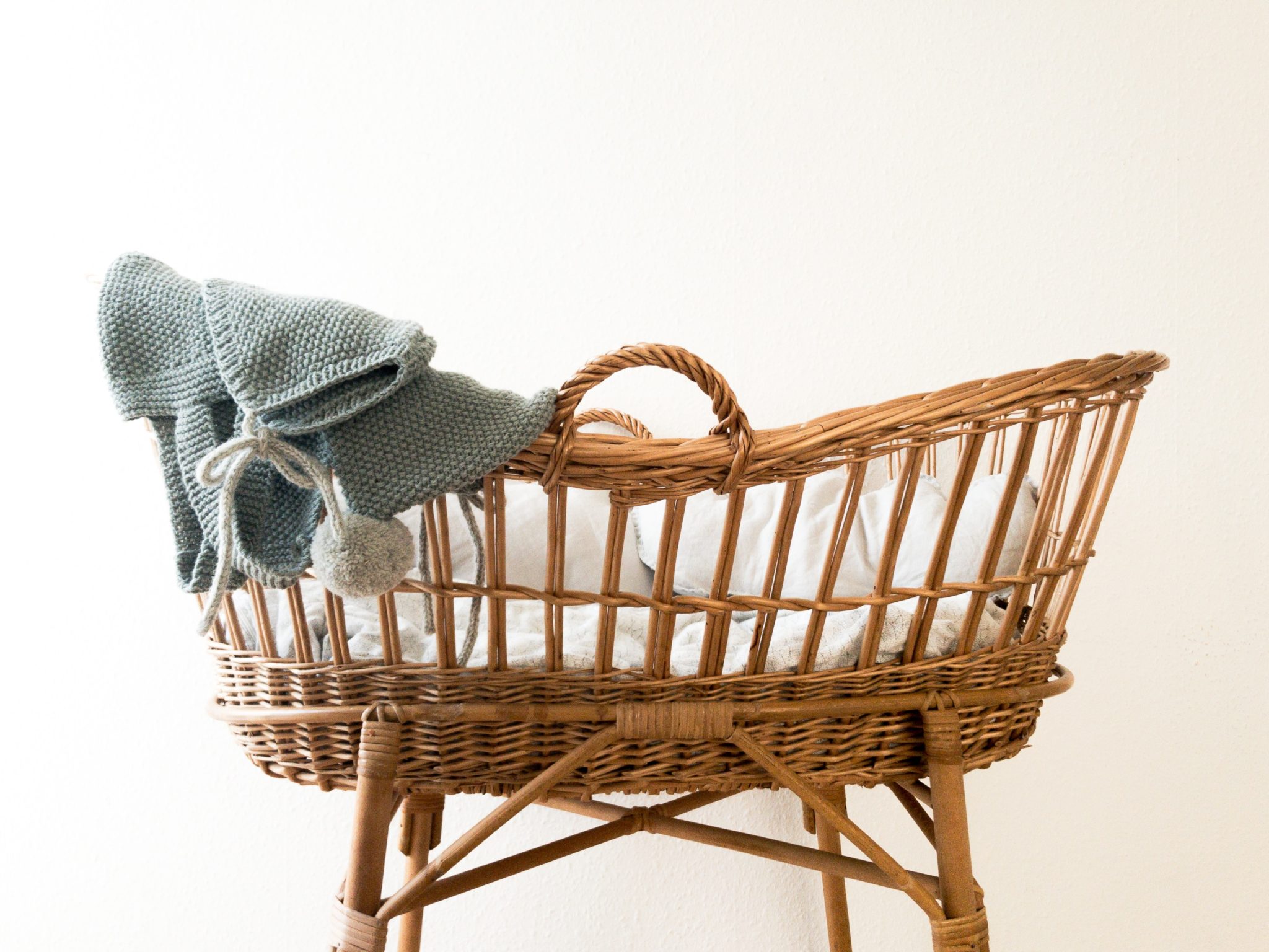 a wicker baby carriage with a blue blanket on top